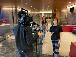 3 students test the C70 camera in a lobby